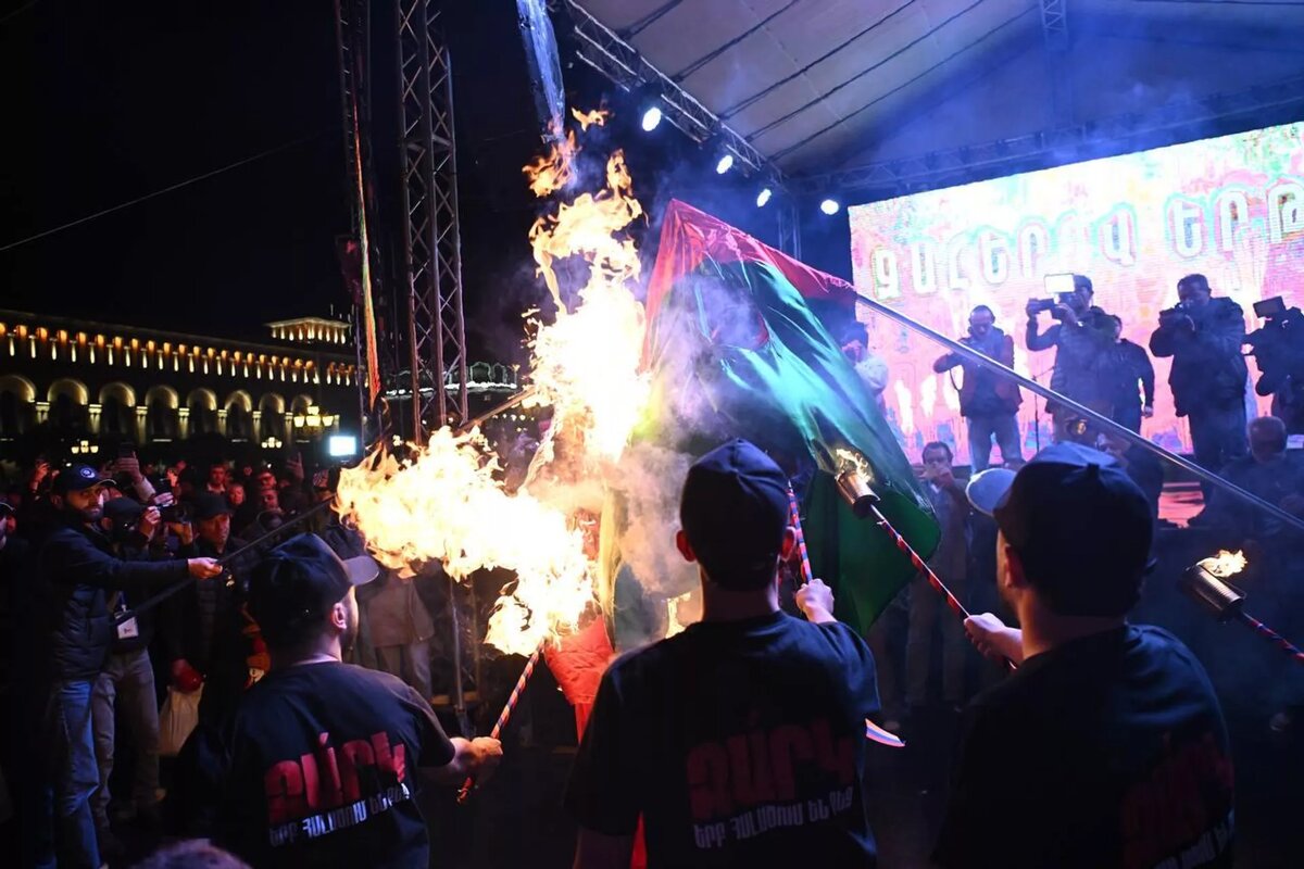 Участники факельного шествия сжигают флаги Турции и Азербайджана на площади Республики (23 апреля 2025). Еревaн
© Sputnik