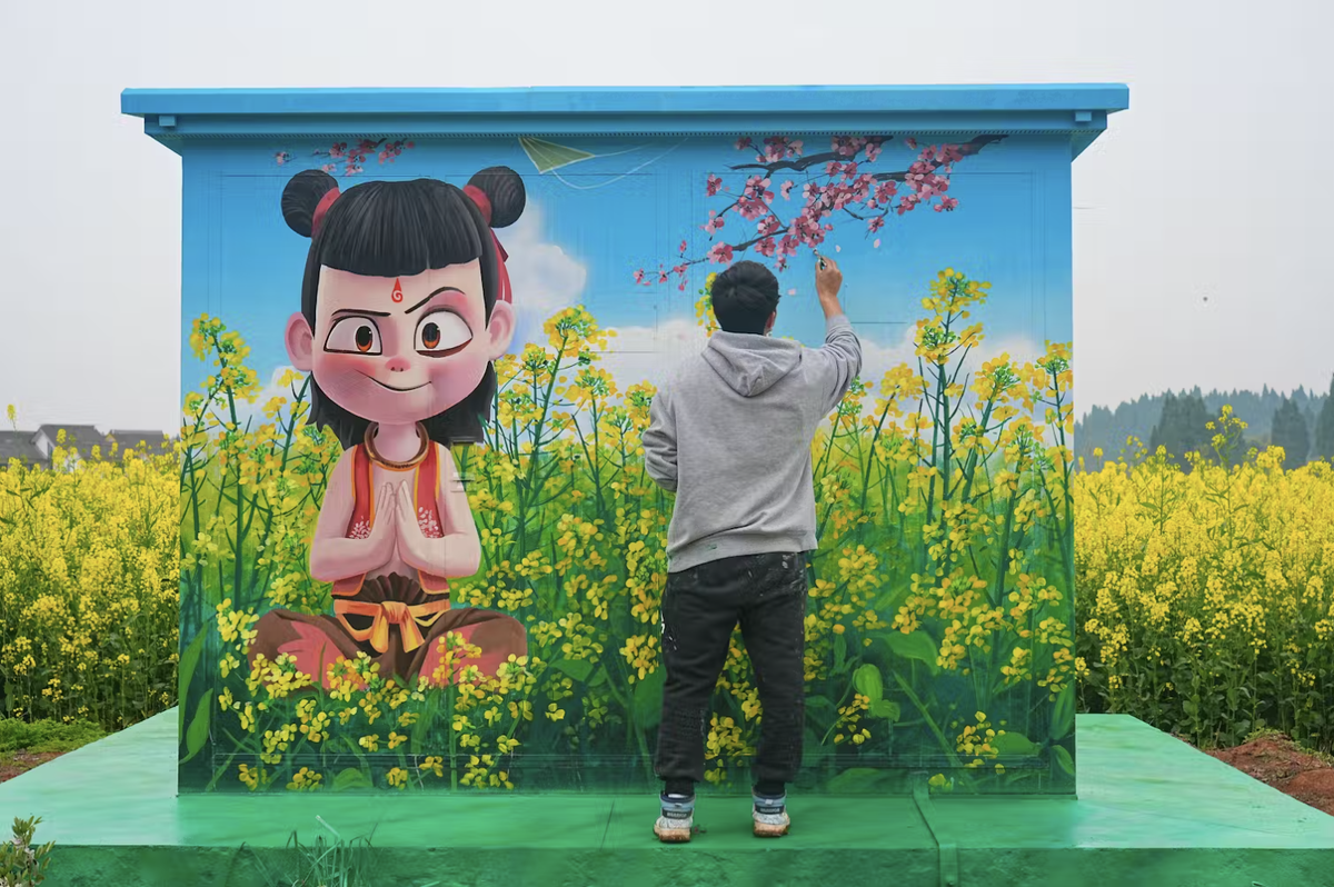 Художник рисует изображение Не Чжа, персонажа из анимационного блокбастера, на распределительном щитке на фермерском поле на юго-западе Китая. Чжун Мин/Feature China/Future Publishing 