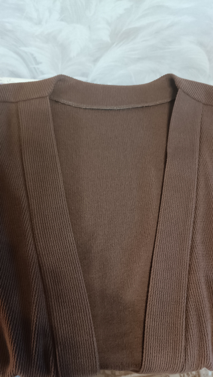 Первым делом надо обработать горловину спинки обтачкой, а борта полочек планками. 