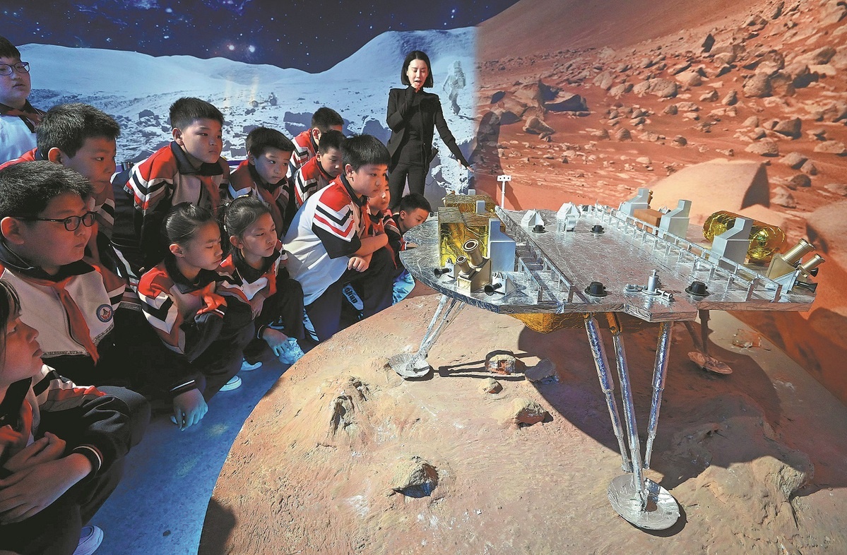 Школьники рассматривают модель посадочной капсулы «Тяньвэнь-1» в музее науки и техники в Ханьдане, провинция Хэбэй, 24 апреля 2024 года.