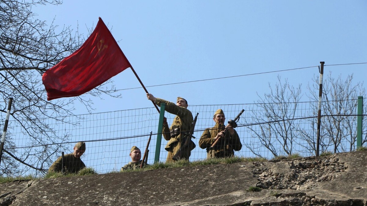    Солдаты Красной Армии поднимают флаг над захваченным фортом номер пять в Кёнигсберге: историческая реконструкция. Фото: Uladzimir Navumenka/Shutterstock/Fotodom