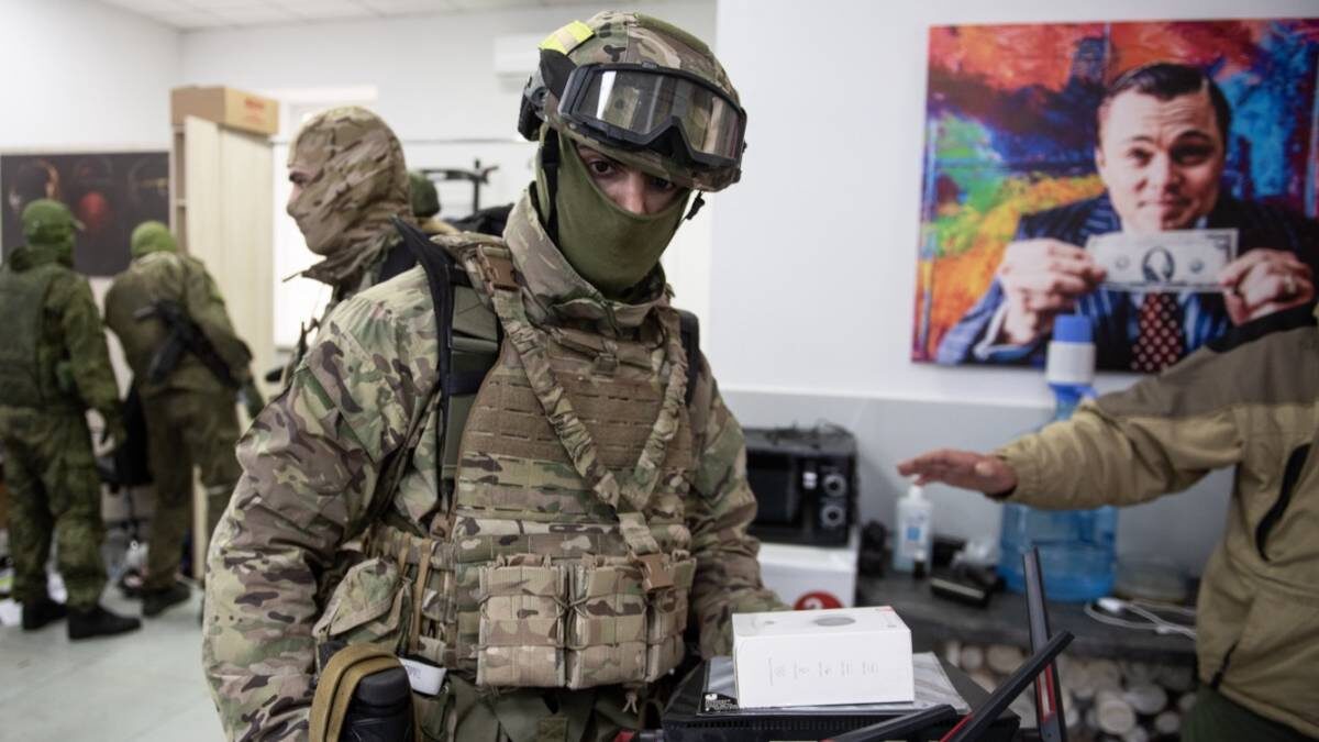    Российские военнослужащие в брошенном украинскими мошенниками кол-центре в Бердянске. Отсюда преступники звонили россиянам под видом сотрудников службы безопасности разных банков и выманивали деньги / Фото: РИА Новости