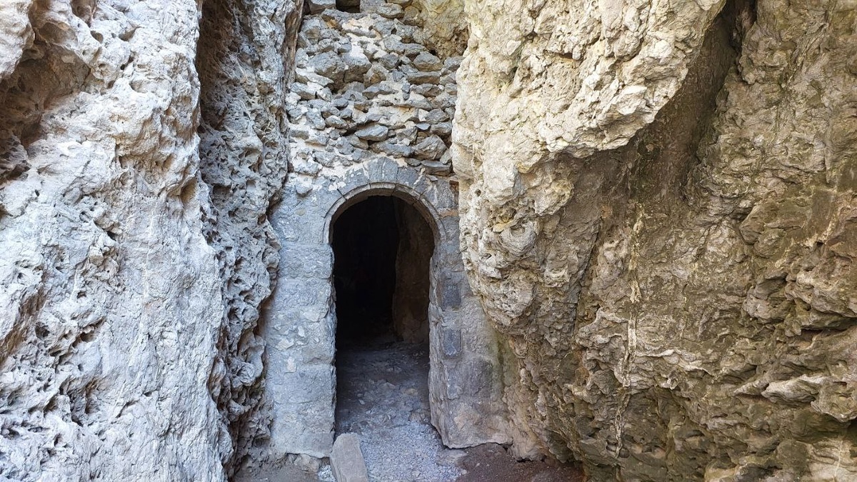 Каменные врата грота: арка, выточенная временем и руками людей, сохранившая дыхание древности.