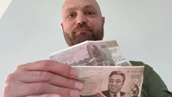 Александр Коц держит фальшивые купюры, который раздавали ВСУшники Фото © Telegram / Kotsnews