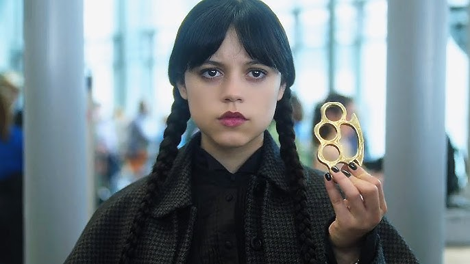 Уэнсдей Аддамс (Дженна Ортега) держит золотой кастет – кадр из популярного сериала Netflix Уэнсдей