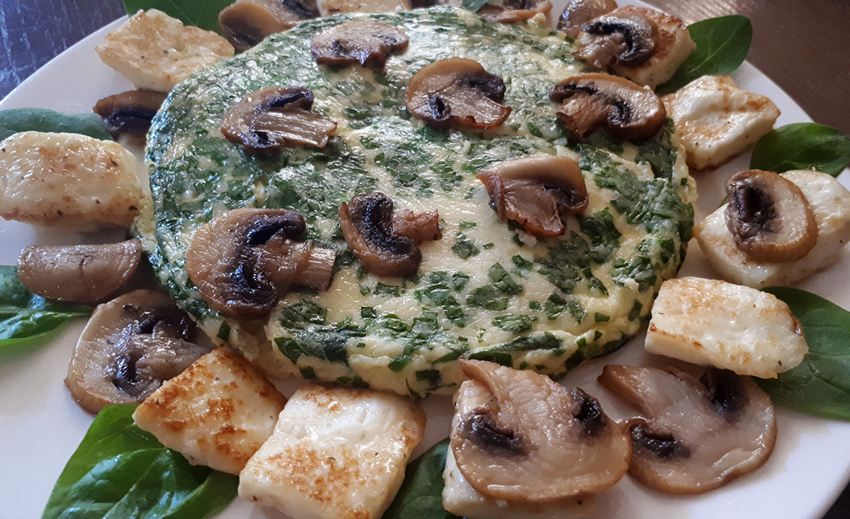 Состав блюда: омлет с зеленым луком, шампиньоны, руколла, обжаренный козий сыр халуми.