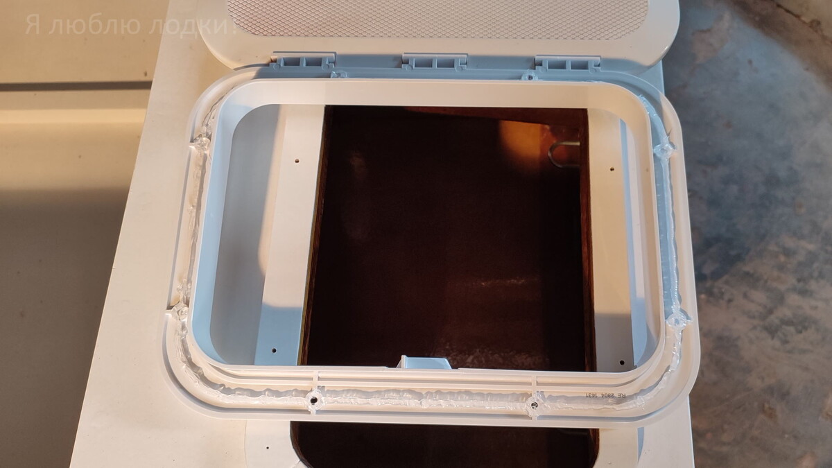 Наношу силиконовый герметик на рамку люка