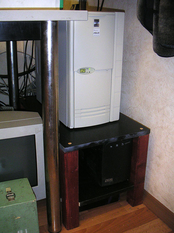 Маршрутизатор стоит на специально сделанной для него подставке. Ниже на полке — источник бесперебойного питания.