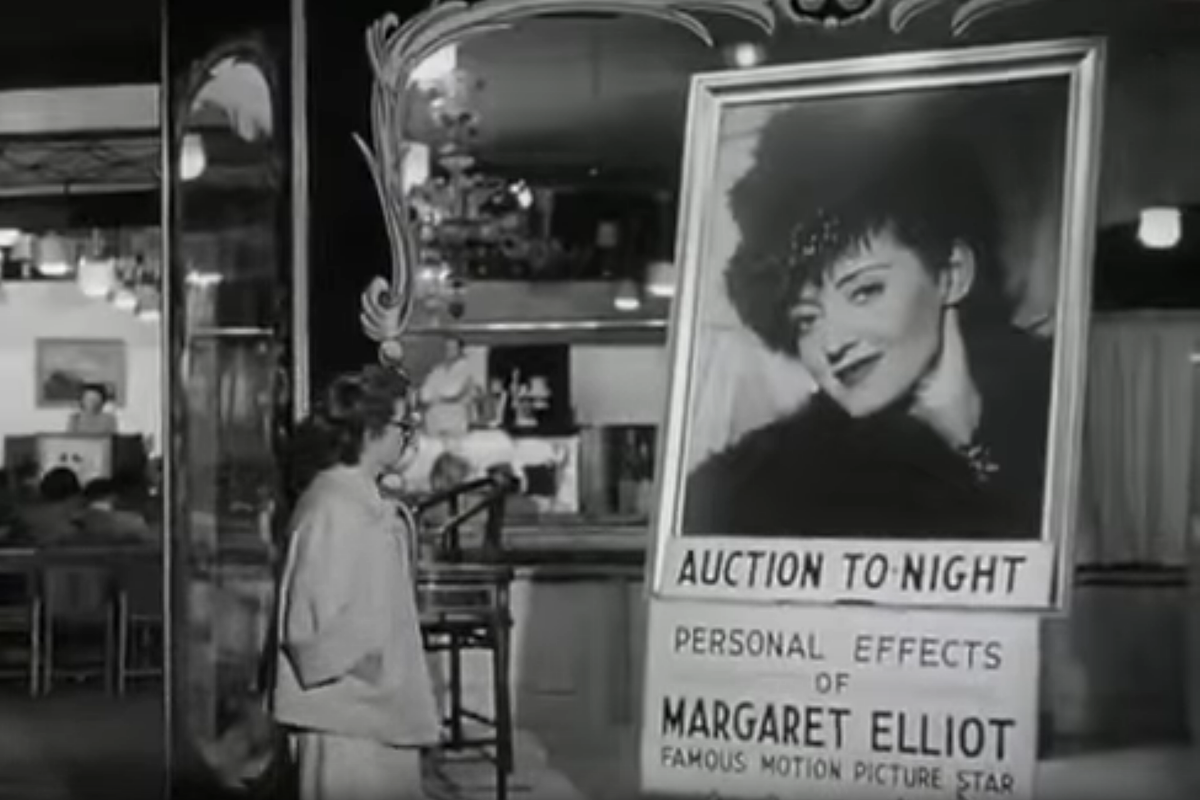 Кадр из фильма "Звезда": главная героиня стоит перед вывеской аукциона, на котором её вещи распродают за бесценок чтобы хот как-то покрыть долги