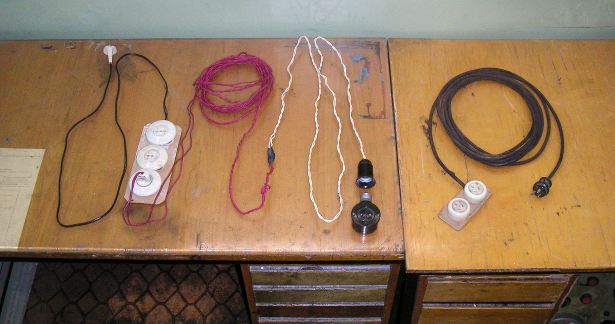 Вот тот самый удлиннитель, который я использовал при сверлении отверстий в стене для крепления электроконтактного манометра. Обратите внимание на розетку, которая вворачивается в патрон лампочки на конце переноски. Справа лежит ещё один удлиннитель, совершенно бесполезный ввиду конструкции его вилки и розеток. Сейчас таких розеток и вилок уже нигде не найти.