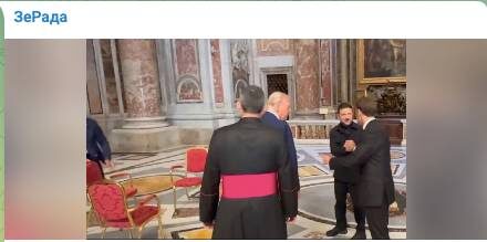   На кадрах стоят три стула, но Трамп уже "выставил" Макрона и тот пожимает руку Зеленскому в знак поддержки. Фото: стоп-кадр видео.