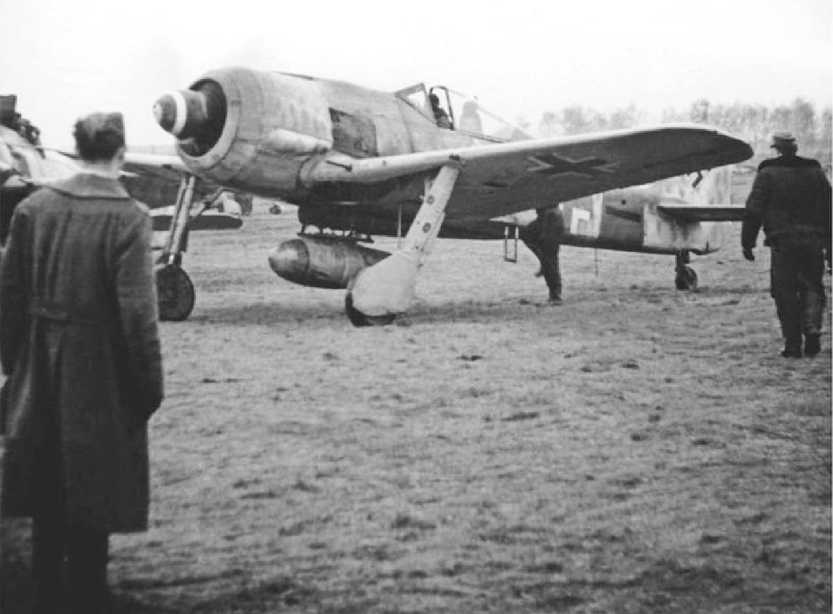 Германские авиационные механики направляются к совершившему посадку самолету "Фокке-Вульф" FW-190A-8/R2 обер-лейтенанта Хайнца-Дитера Грамберга из 8-го штаффеля истребительной эскадры JG 300. Германия, аэродром Лёбнитц, декабрь 1944 года.