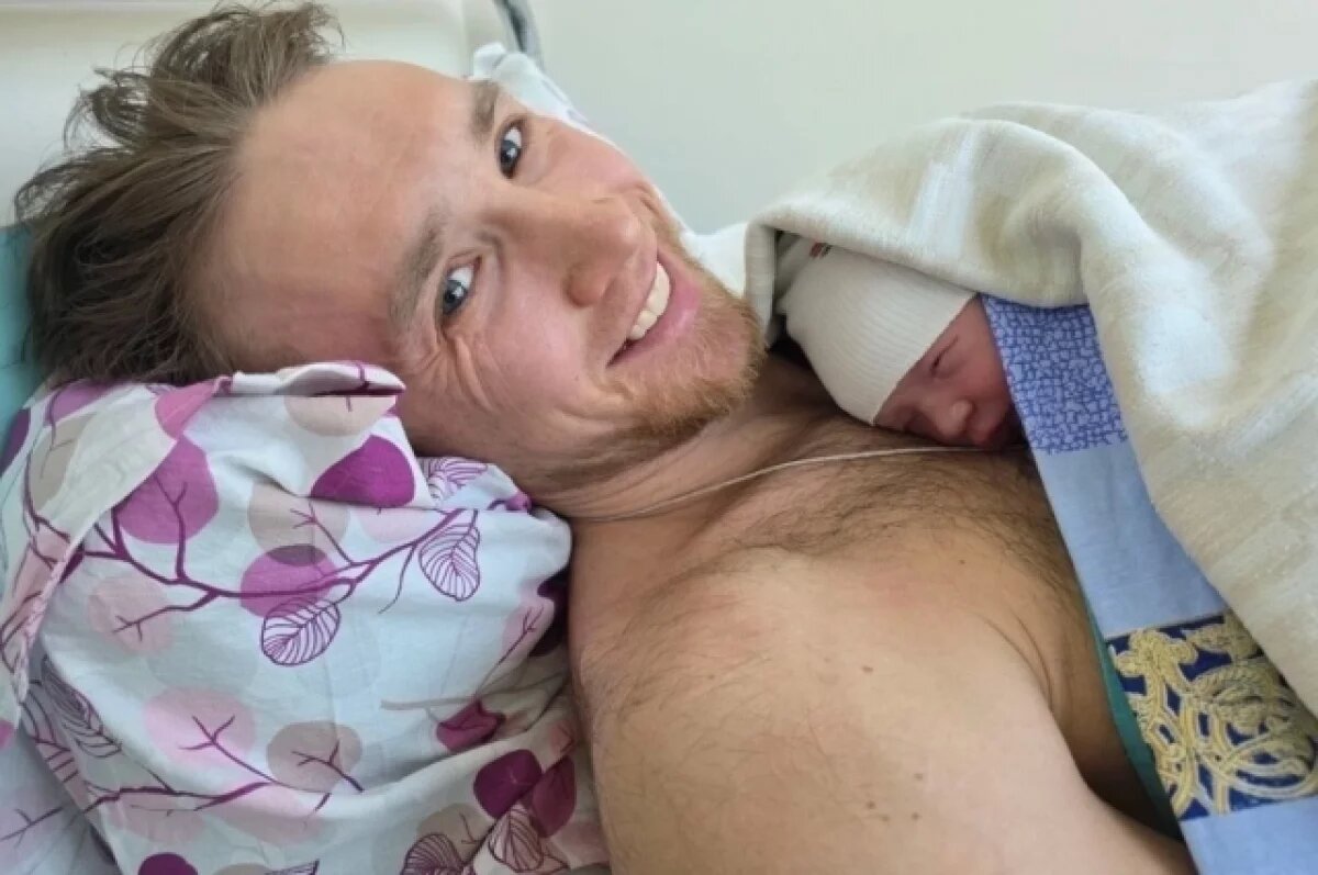    Пока мама отдыхает, папе дали подержать младенца.