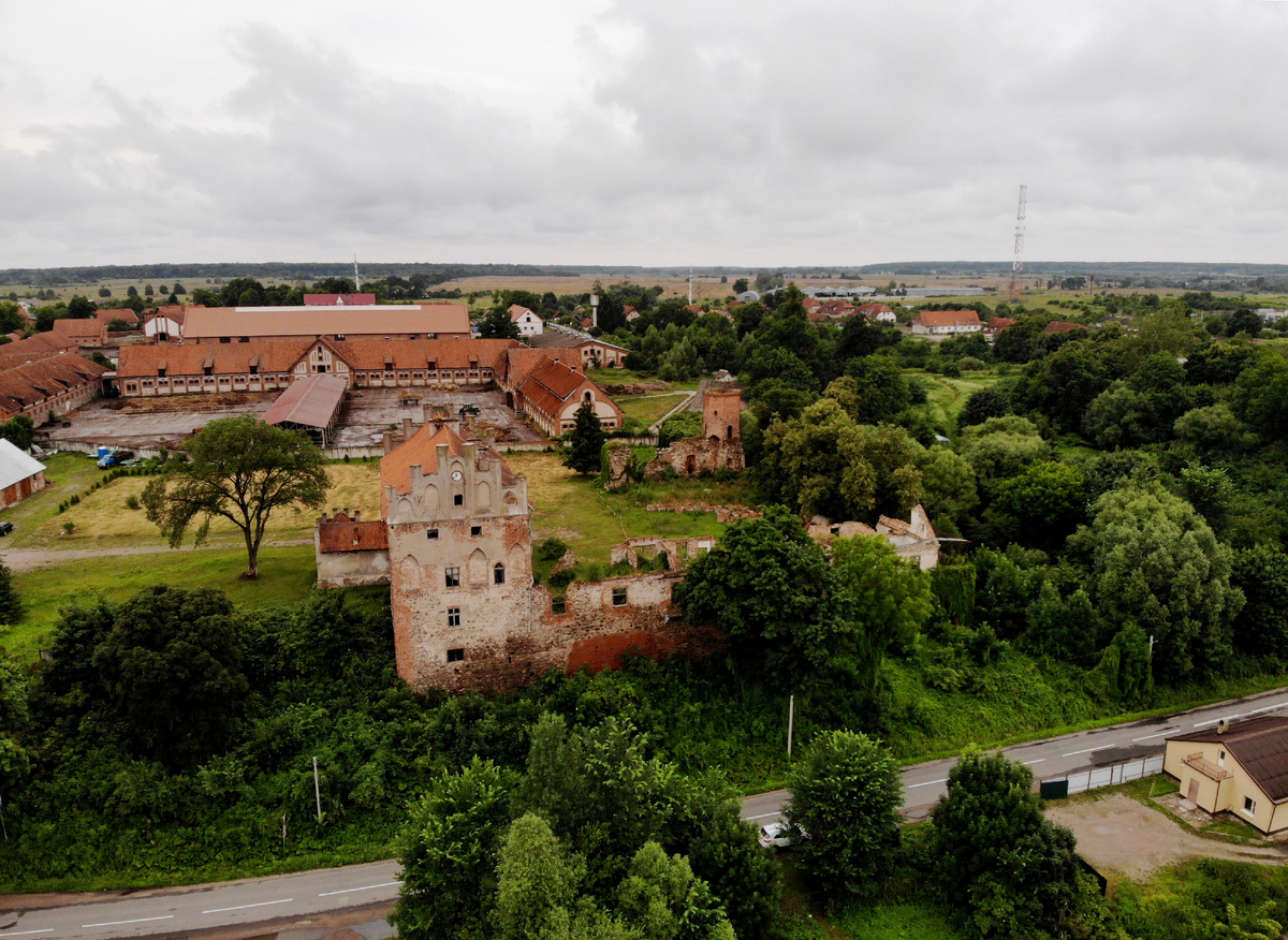 На переднем плане - сохранившийся трёхэтажный флигель с одноэтажной пристройкой. На заднем плане конный клуб.