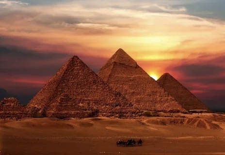 Египетские пирамиды на фоне заката Солнца выглядят особенно красиво, подчеркивая всю красоту и масштабность пирамид