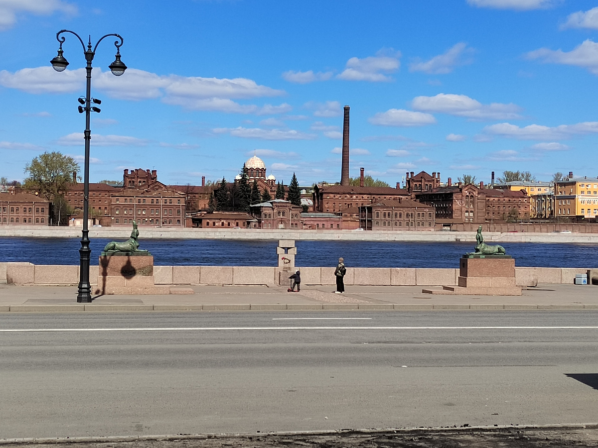 Справа и слева сфинксы. По центру четыре камня, между которыми тюремная решётка в виде креста, под камнями "терновый венец" из колючей проволоки.