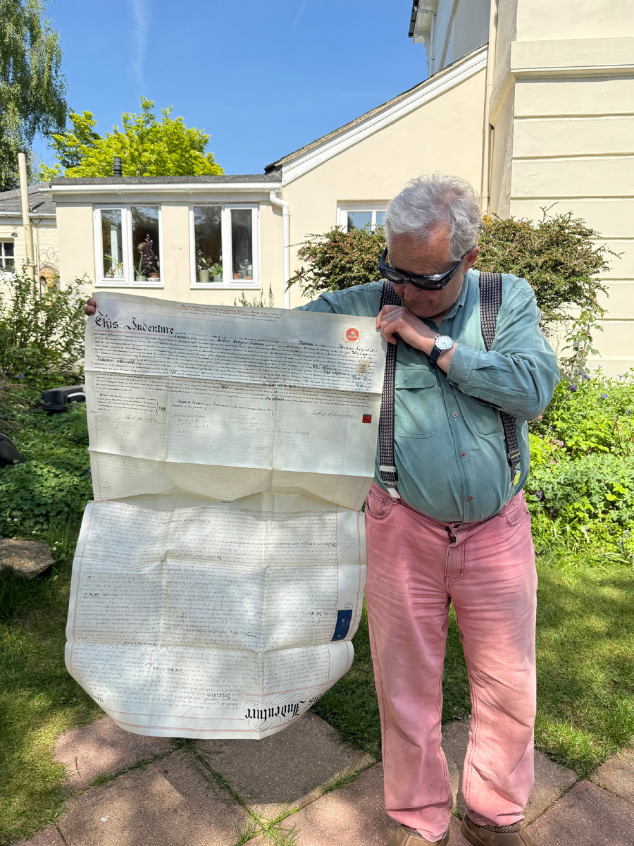 Хозяин дома показывает документ о купли-продаже дома. Смотрите, какой он гигантский! А как красиво написан текст! Интересно, сколько времени заняло написать его? Фотография из личного архива.