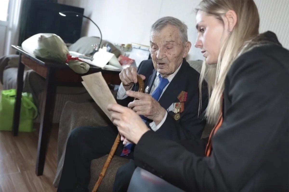    Арсений Михайлович Сухопаров показывает фотографии военных лет.