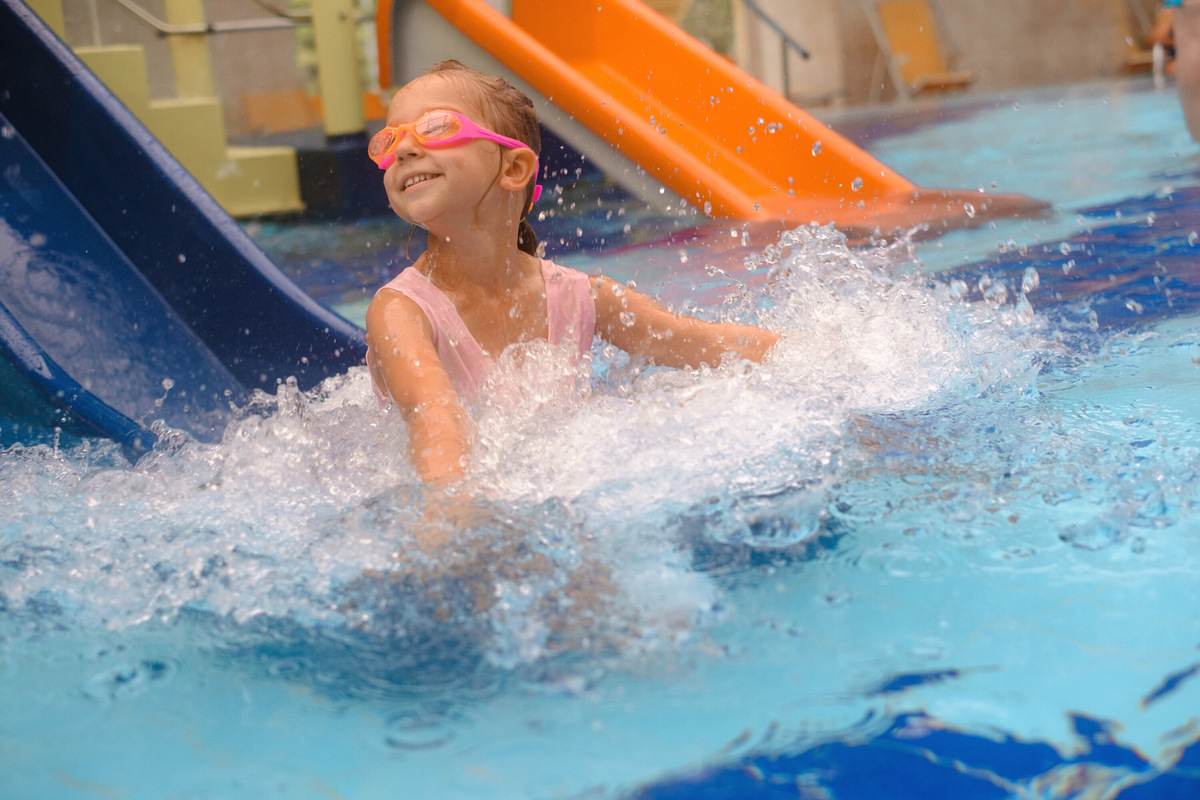 На территории аквапарка есть 10 бассейнов, в том числе гидромассажных и с волнами, три водные горки для взрослых и детская игровая зона с качелями и горками — настоящий водный городок