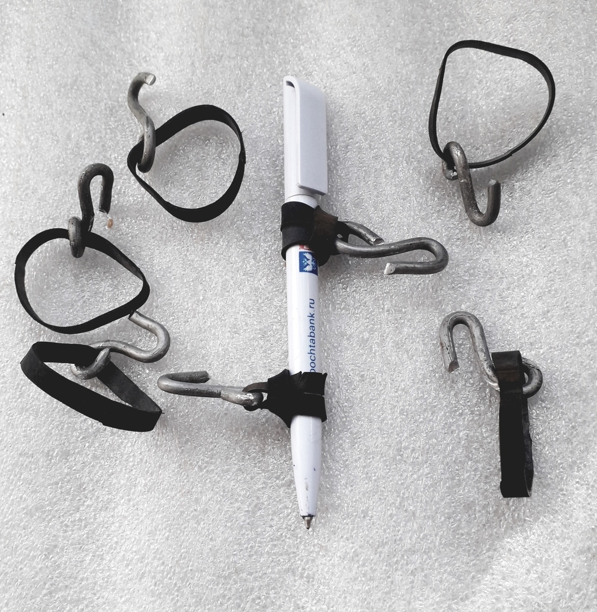 Фото 1. Крючки с резиновыми кольцами. Для наглядности показано крепление резиновых колец на ручке, как на стебле томата.