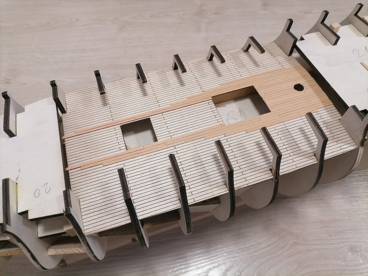 Как видим, шпангоуты (полу-бимсы) сильно мешают. Палубу пришлось согнуть почти вдвое. Здесь часть реек уже наклеена (после вставки палубы, конечно). Раскладка настила изменена.