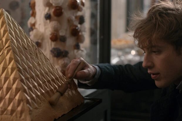 На кадре из сериала Apple TV+ «Карем: Повар королей» Карем (в исполнении Бенжамена Вуазена) наносит финальные штрихи на кулинарную композицию в форме египетской пирамиды. (Фото: Apple TV+)