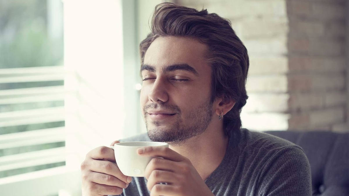 парнеь пьет кофе