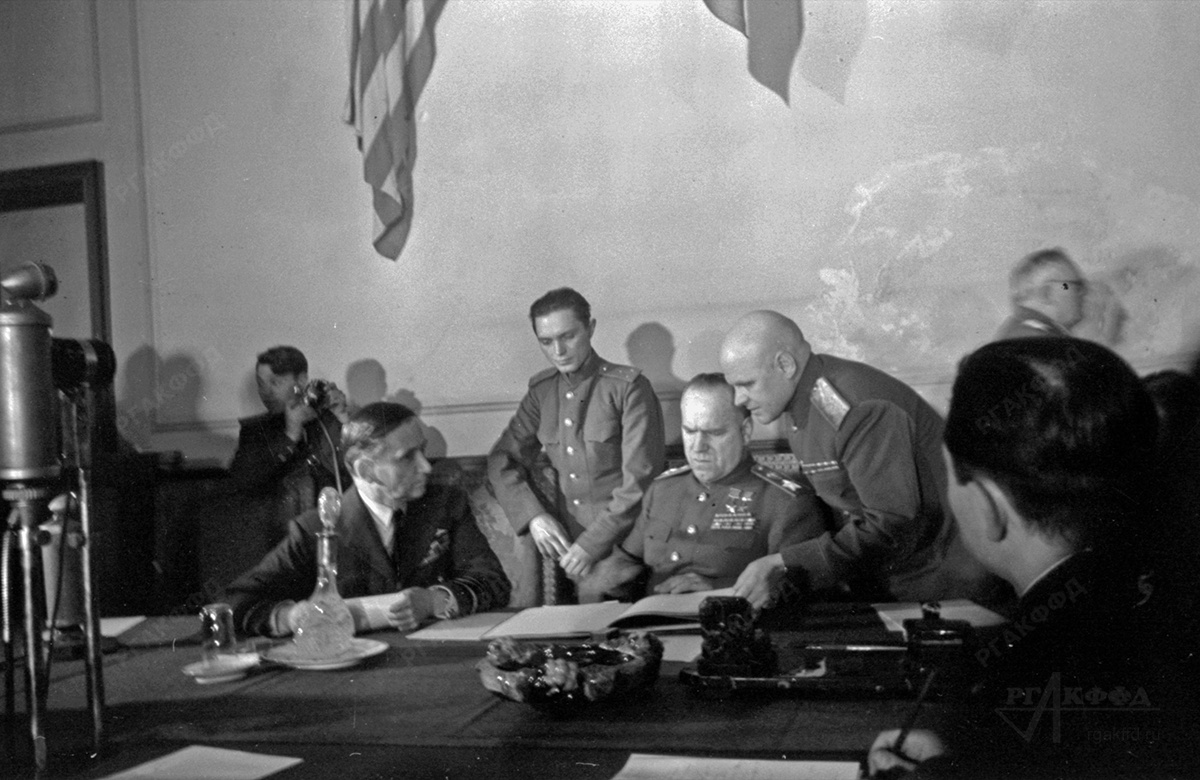Маршал Советского Союза Г.К. Жуков (в центре) подписывает акт о капитуляции Германии. Среди присутствующих генерал-лейтенант К.Ф. Телегин (3–й справа). / г. Карлхорст. 08.05.1945 г. / РГАКФФД. Арх.№ 0-347128