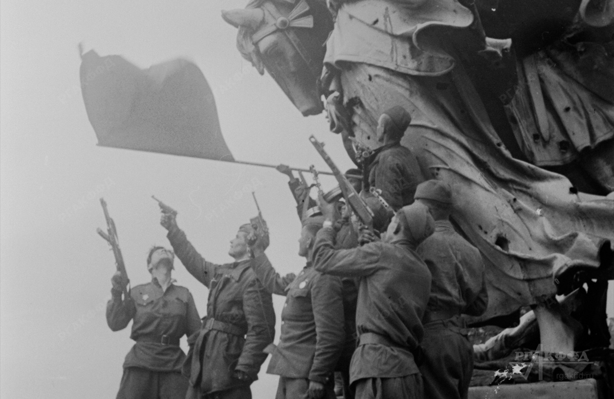 Советские солдаты на крыше Рейхстага салютуют в честь водружения Красного знамени. / Берлин, май 1945 г. / РГАКФФД. Арх.№ 0-320061