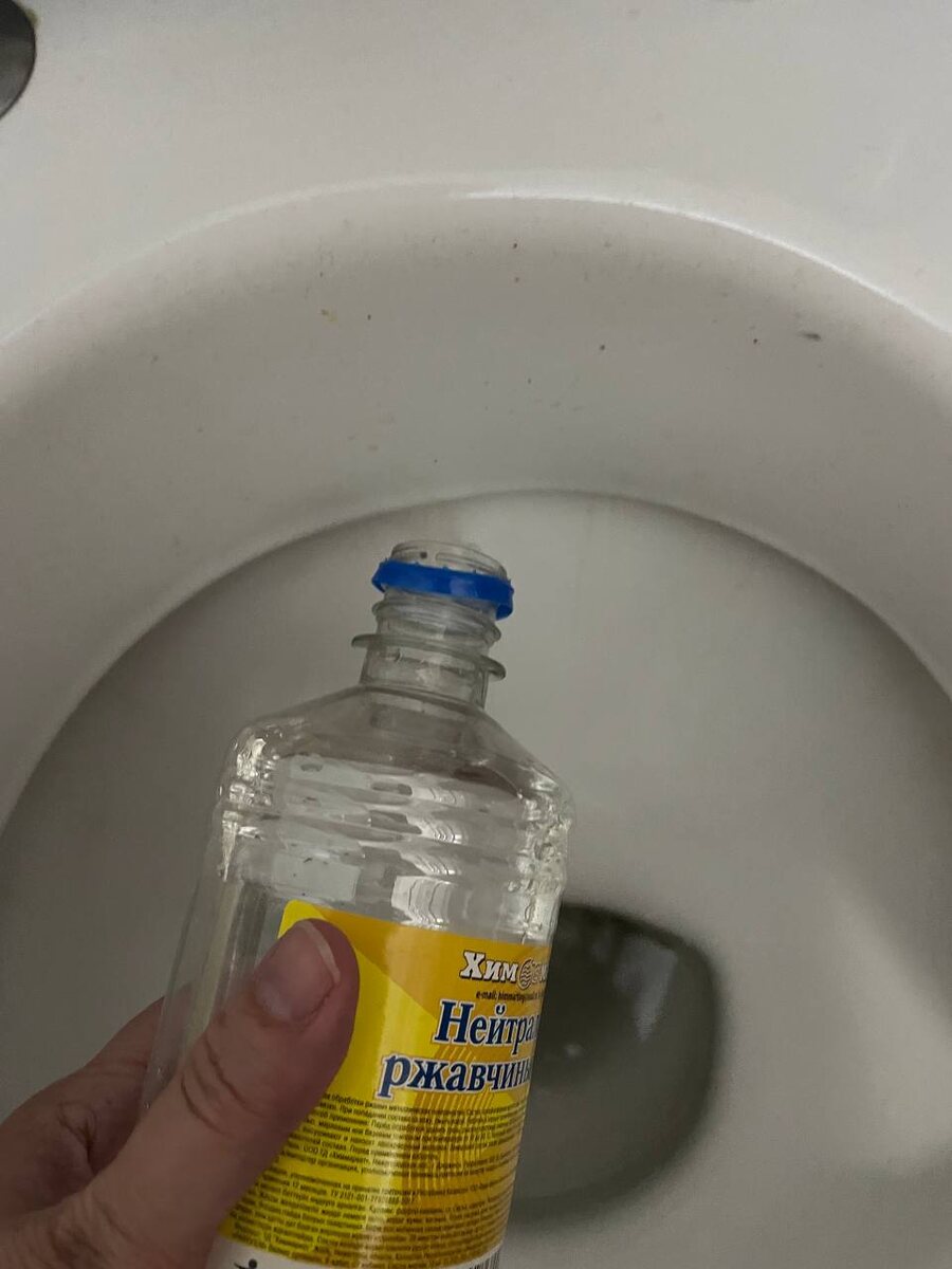 Подруга поливает потеки ржавчины средством и заодно средство стекает в колено, где оно будет также находиться какое-то время. 