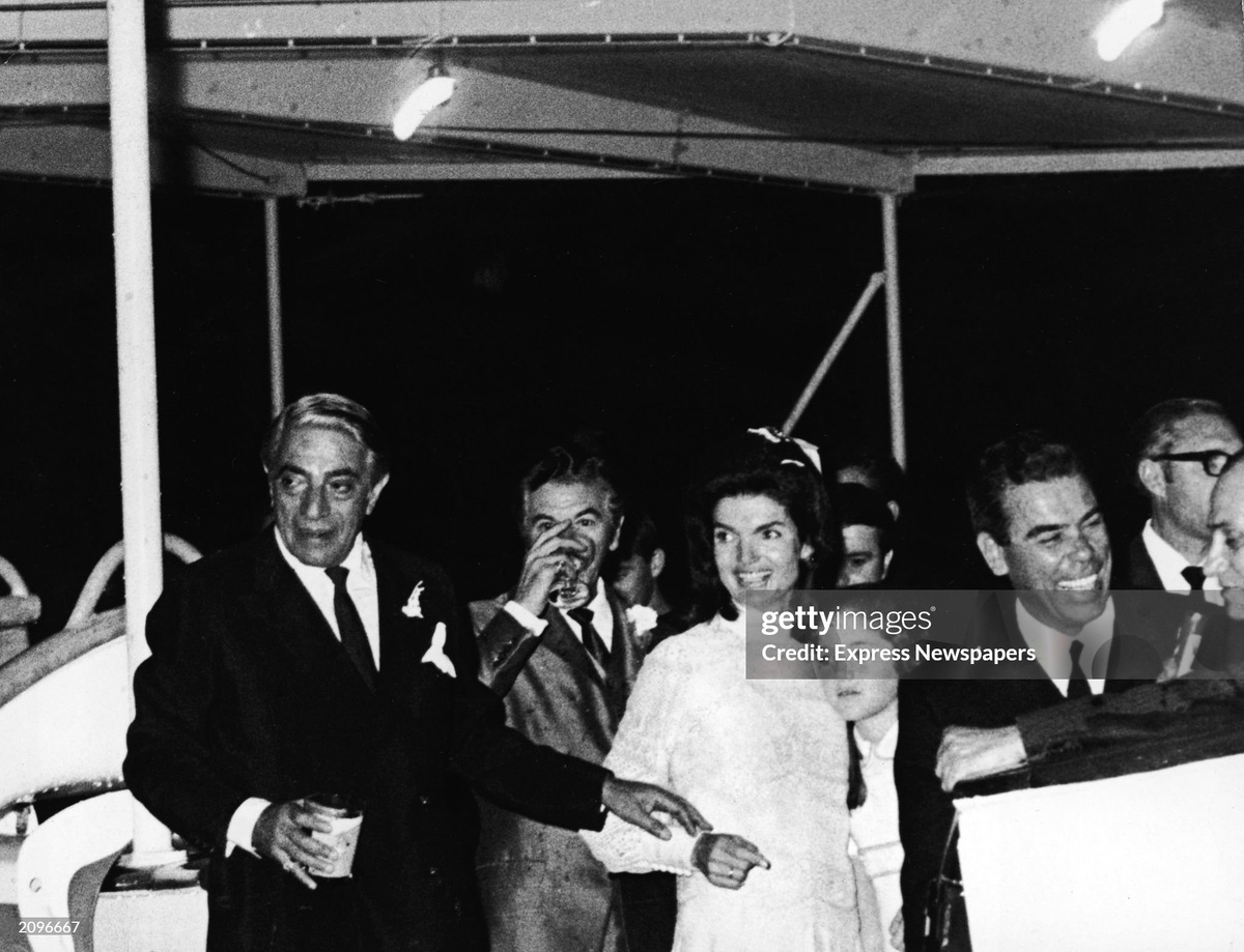 Жаклин Кеннеди Онассис обнимает свою дочь Кэролайн Кеннеди и своего нового мужа, греческого судоходного магната Аристотеля Онассиса, устраивают прием на борту яхты «Кристина» вскоре после церемонии бракосочетания на острове Скорпиос, Греция, 21 октября 1968 года.