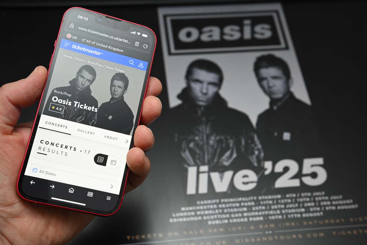 Фанат пытается купить билеты на реюнион-тур Oasis 2025 года с помощью смартфона. Фото: Oli Scarff/AFP/Getty Images