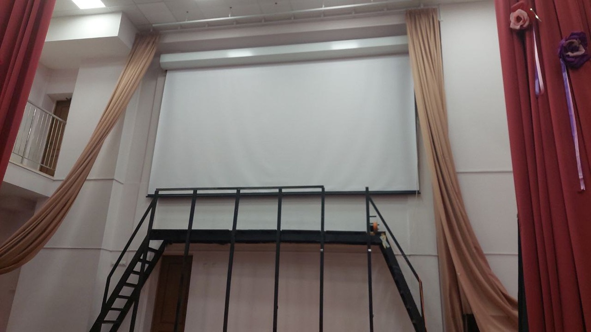 Моторизированный экран шириной 6 метров Кубстер в актовом зале школы