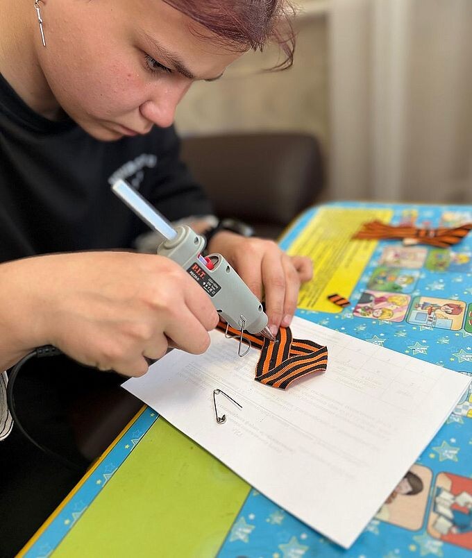 Девочка-подросток склеивает части медальона