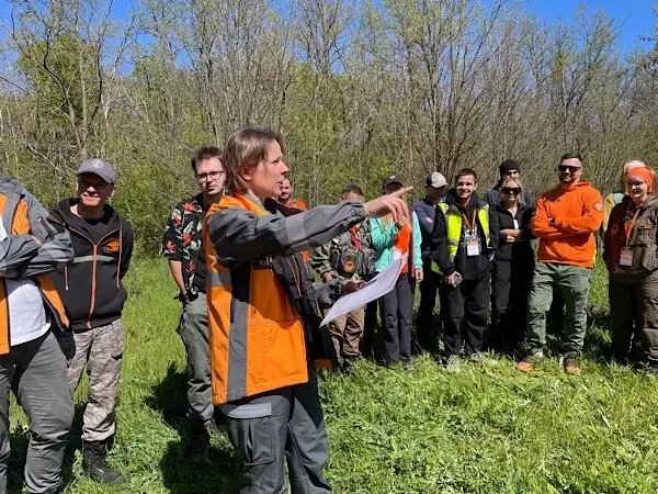 Что касается опытных «бойцов», у них было не менее насыщенное обучение. Для волонтеров подготовили программу, где обучают эвакуации найденного из леса, а также оказанию первой помощи.На майских праздниках в Ростовской области прошли учения добровольцев отряда «ЛизаАлерт». Десятки волонтеров, как бывалых, так и новичков, пожертвовали своими выходными, чтобы принять участие в учениях. Корреспондент DonDay провел весь день с добровольцами и узнал, как проходят поиски людей в лесу.📷
Добровольцы разделились на две команды: опытные поисковики и новички. Особое внимание уделялось обучению людей, которые только примкнули к отряду, поскольку в лесной местности искать людей в разы тяжелее и опаснее, чем в городе. Главное правило волонтеров ПСО — это не увеличить количество пострадавших, поэтому учат помогать людям, но без вреда для собственной жизни. В лесу есть ряд опасностей: насекомые, острые ветки, ухабистая дорога или овраги, а также плохая связь и отсутствие электроприборов, которые могли бы помочь. Чтобы с этим со всем не столкнуться, первое, на что обращают внимание, — это одежда. У волонтера она должна быть закрыта. На ногах – высокая обувь, чтобы держала голеностопы, головной убор и обязательно очки.📷
Новички да и опытные добровольцы по одному в лес на поиски никогда не ходят, обычно от 2 до 5 человек. У группы должны быть у каждого фонарики, навигатор, запасной аккумулятор, вода, перекус и, конечно же, средство связи — рация. Ее дают только ведущему в группе. И обязательный спасательный набор, в случае, если найдет исчезнувшего.📷
Только прибывших волонтеров обучили пользоваться навигатором, компасом, рацией, разбираться в картах. Кроме средств для поиска, рассказали и про методы. В основном в полевых условиях ищут людей «на отклик», то есть добровольцы на определенном участке кричат имя или прозвище пропавшего. Но это не всё так просто. Здесь учитывают погодные условия, расстояние и т. д. Кроме того, пропавший человек может потерять сознание и не ответить. Тогда прибегают к крайнему методу поиска — прочес. Осматривают область поиска, проходя её змейкой, – очень длительный и трудоемкий прием.        
 
Несмотря на всевозможные риски и большой объем работы волонтера, неравнодушные люди все равно идут на это все осознанно. Кто вообще ждет вступления в волонтерство целых пять лет. Надежда Головченко, офисный работник, заботливая мама двух детей, очень долго ждала того, чтобы стать добровольцем.📷
— Пять лет назад, когда была беременна вторым ребенком, увидела выпуски «Вернувшиеся» (прим. ред. – это программа, где рассказывают личные истории людей, столкнувшихся с исчезновением их близких), мне стало очень интересно, — делится Надежда. — Стала понимать, что в отряде мало людей и что нужна помощь. Пять лет ждала, когда вырастет ребенок и я смогу активно участвовать в поисках.
И вот мечта Надежды сбылась. Она обучается поискам людей и уже готова помогать.       
 
Не всегда приход в отряд связан с желанием помогать чужим, иногда он связан с желанием помогать своим. Так, случай Ульяны Александровой наверняка послужит примером для многих. В январе 2025 года пропал близкий друг семьи Ульяны. Тогда на протяжении нескольких недель не было никакой информации о человеке, и женщина решила сама пойти его искать.📷
— Хотелось иметь больше информации о нашем пропавшем друге, — рассказывает Ульяна. — Искала вместе со всеми волонтерами, после даже втянулась. Параллельно даже занималась прозвонами (прим. ред.: это когда волонтер прозванивает больницы, отделы полиции и т. д. в поисках пропавших), поскольку я офисный работник, на постоянные активные поиски у меня не было времени. Таким способом мне даже удалось найти бабушку, чему я была очень рада.
К сожалению, спустя три месяца близкий друг Ульяны был найден мертвым, однако она не оставила волонтерство и продолжила обучаться и помогать людям.📷
