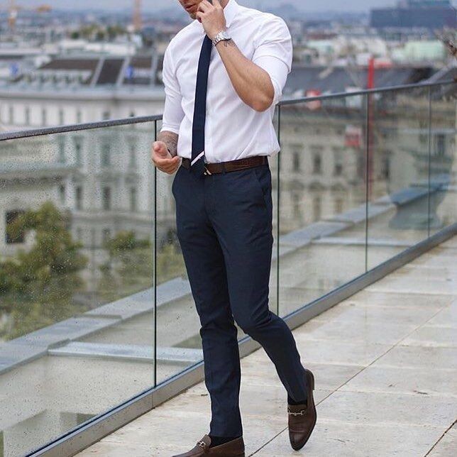 Мужчина в белой рубашке и тёмно-синих брюках