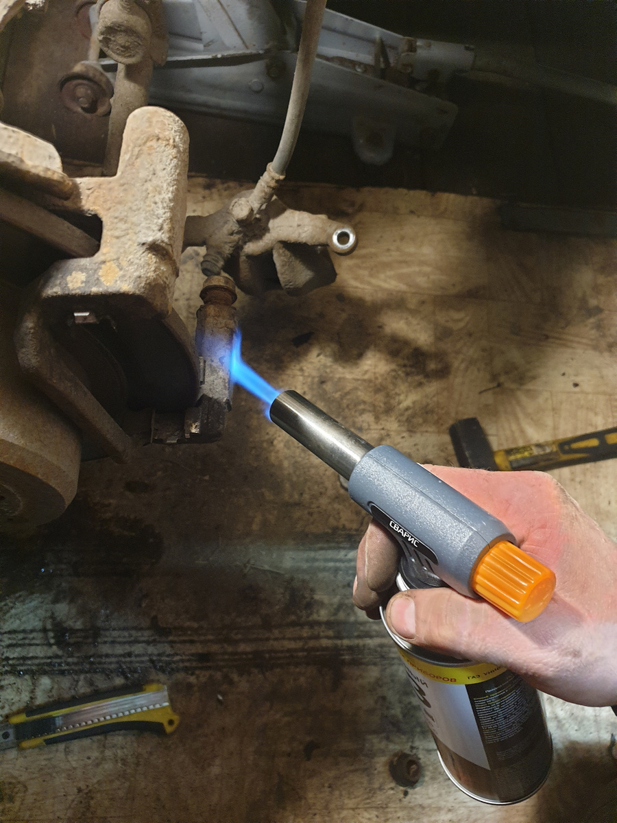 Аккуратно отжимаем суппорт — важно не повредить тормозной шланг