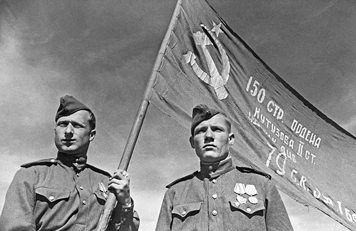    Разведчики младший сержант Мелитон Кантария и сержант Михаил Егоров (слева направо) со штурмовым флагом 150-й Идрицкой ордена Кутузова II степени стрелковой дивизии (знамя Победы), который был водружен ими на крыше Рейхстага. Берлин, май 1945 года.  Владимир Гребнев/ТАСС