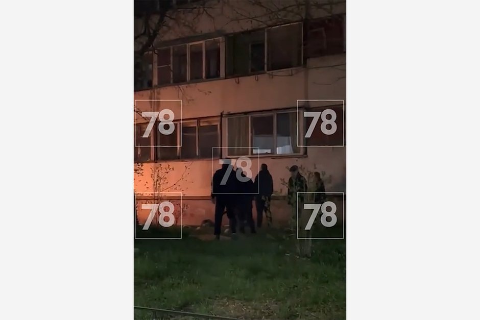 Люди рядом с девушкой, спрыгнувшей с балкона в доме на Ленинградской улице во Всеволожске. Кадр: 78.ru