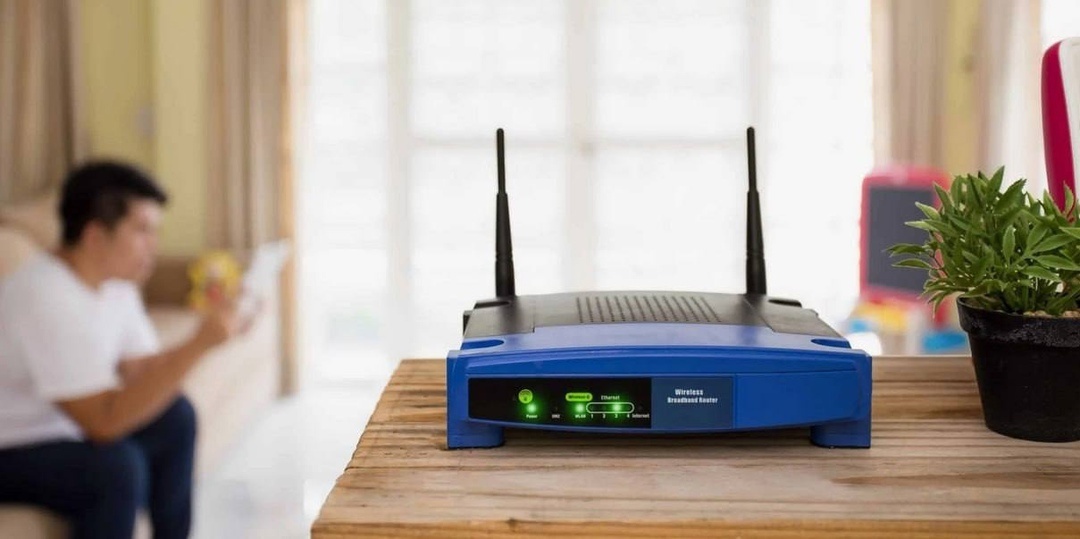 1. Легковоспламеняющиеся материалы
У моего друга роутер стоял в шкафу для верхней одежды. По классике на него упала куртка. Итог - роутер оплавился и чуть не привел к пожару. Причина — плохая вентиляция. Роутер сильно греется, особенно если подключено много устройств.

Важно: не ставьте роутер в закрытые шкафы, под кучу тряпок или рядом с бумагой. Огонь вспыхивает не от сигнала Wi-Fi, а от перегрева и возможного короткого замыкания.

❌ 2. Металлические предметы и зеркала
Металл отражает сигнал. Сейф, батарея, металлическая дверь или даже зеркало с металлическим напылением могут значительно ослабить Wi-Fi. А вы будете ругаться на роутер, не зная, что мешает — зеркало!

Факт: в зеркалах часто используется металлическое напыление, поэтому большие зеркала действуют почти как экраны, отражающие сигнал обратно.

❌ 3. Аквариумы и вода
Вода поглощает радиоволны. Аквариум, ваза, бутылка с водой — всё это буквально «глушит» сигнал. Проверьте: поставьте пятилитровку рядом с роутером и посмотрите уровень сигнала в приложении — будет хуже.

❌ 4. Бытовая техника
Микроволновки, телевизоры, холодильники, особенно старые, могут создавать электромагнитные помехи, ведь работают на той же частоте 2,4 ГГц.

Совет: если у вас двухдиапазонный роутер, переключитесь на частоту 5 ГГц — она менее подвержена помехам и работает быстрее. Правда, радиус покрытия у неё меньше, и стены влияют сильнее.

❌ 5. Люминесцентные лампы
Старые “энергосберегайки” могут создавать шум в радиочастоте и мешать работе Wi-Fi, особенно при включении.

❌ 6. Книги и мебель
Шкаф, сервант, полка с книгами — всё это ослабляет сигнал. Даже если предметы не металлические, они могут физически блокировать прохождение волны.

❌ 7. Спальня
Хотя наукой не доказан вред от Wi-Fi, специалисты советуют не ставить роутер в спальне — особенно у изголовья кровати. Лучше размещать устройство в общей зоне.

❌ 8. На полу
Пол — не лучшее место. Особенно бетонный. Сигнал уходит вниз, роутер быстрее пылится, выше риск случайно зацепить.

С