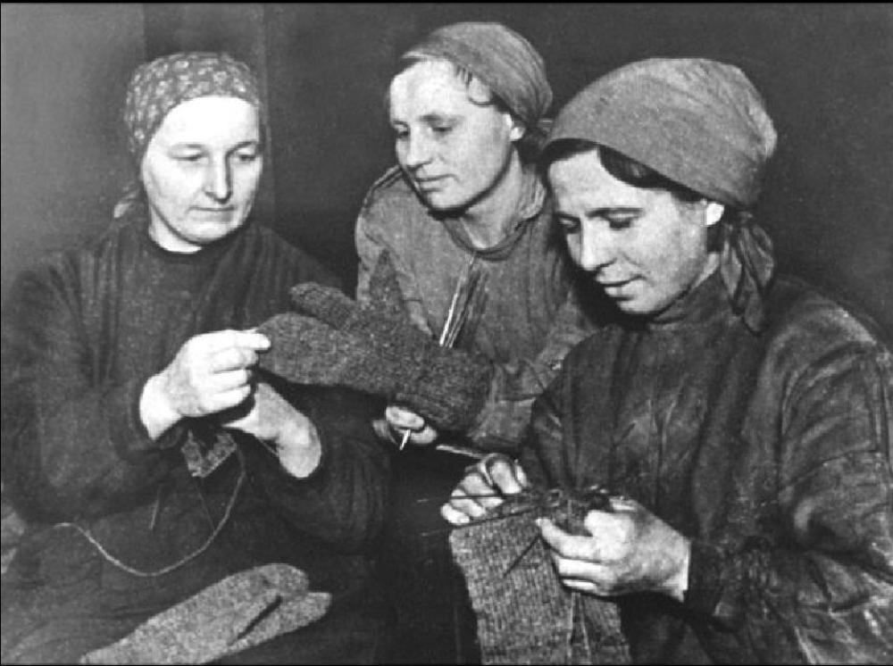 Три советские женщины в тылу войны вяжут варежки для бойцов. Их труд – часть тысяч нитей поддержки, связывавших тыл и фронт (архивное фото).