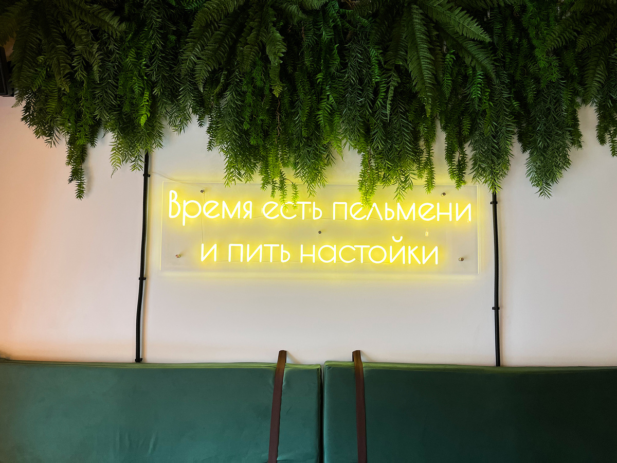 Неоновая вывеска на одной из стен призывает есть пельмени и пить настойки →