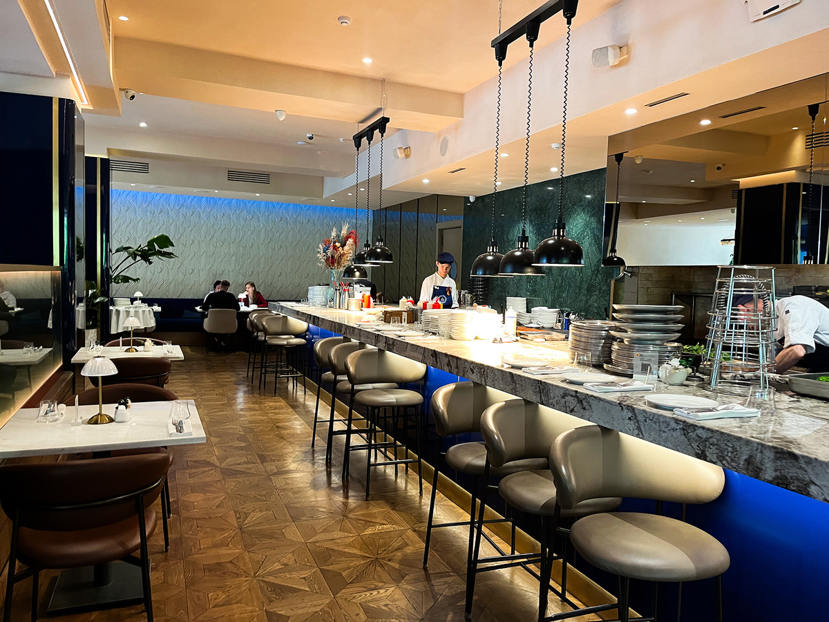 Открытая кухня тянется по периметру всего пространства →