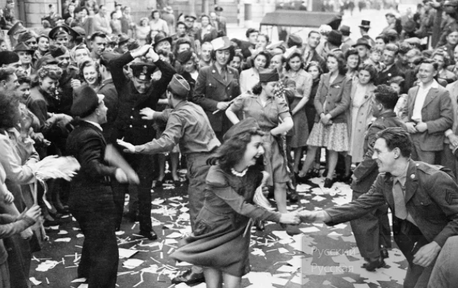 Британские девушки танцуют на улице с американскими солдатами во время празднования "Дня победы" в Лондоне 8 мая 1945 года.