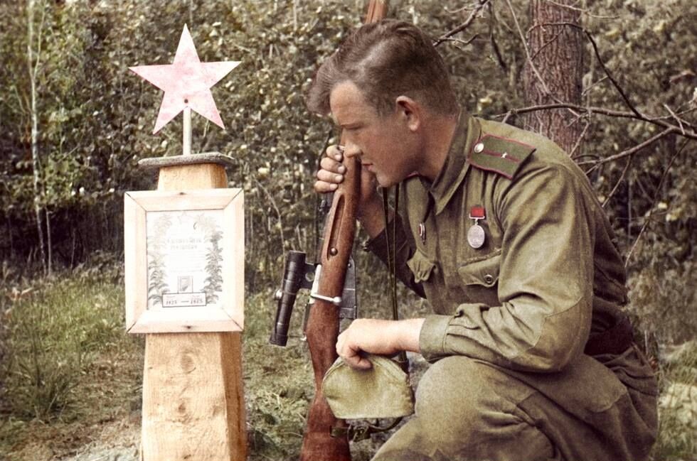 Снайпер 61-й армии Младший лейтенант Иван Лебедев ( на его счету 203 убитых немца ) у могилы своего боевого товарища. Брянский фронт. 1943 год / Фото отредактировано в цвете от kosta26