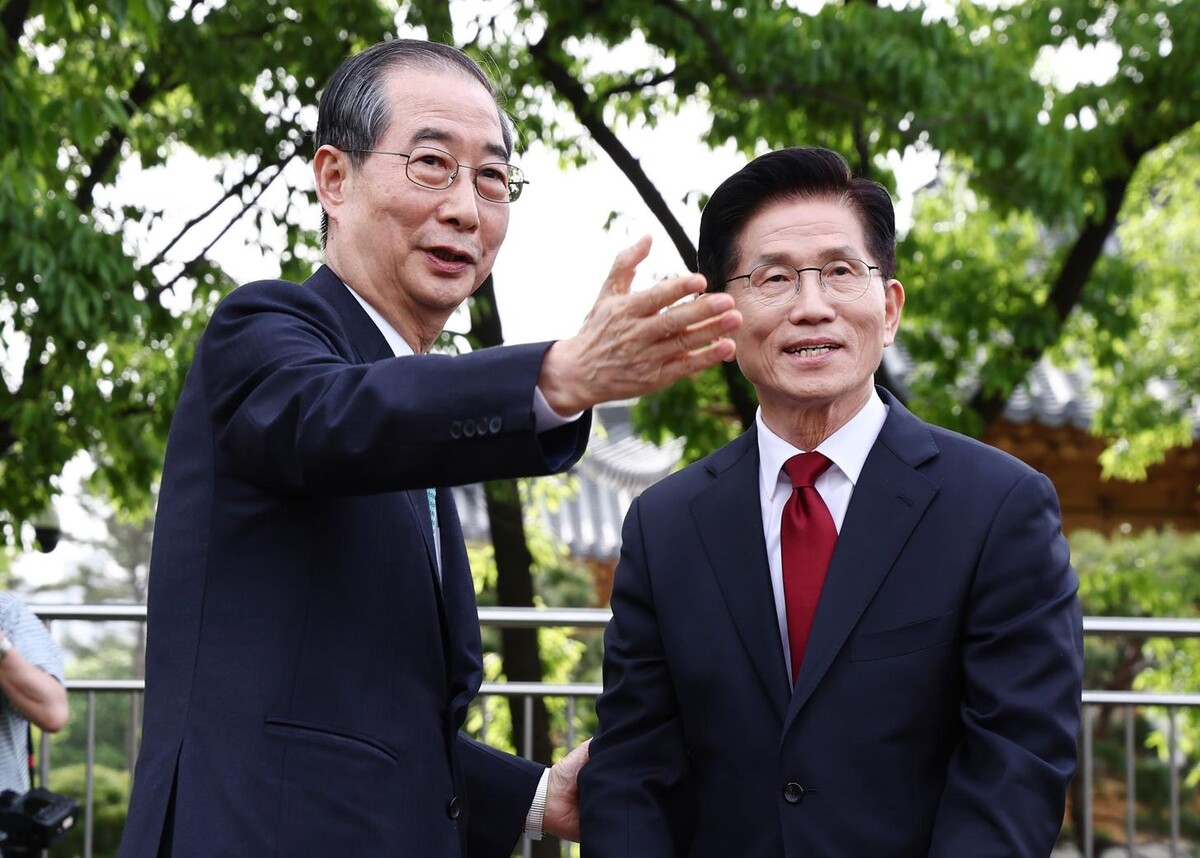 Соперники от Народной партии: Хан Дак Су, слева, бывший премьер-министр и независимый кандидат в президенты, и Ким Мун Су, бывший министр труда и кандидат в президенты от консервативной партии "Сила народа", общаются во время встречи в Национальной ассамблее в Сеуле.