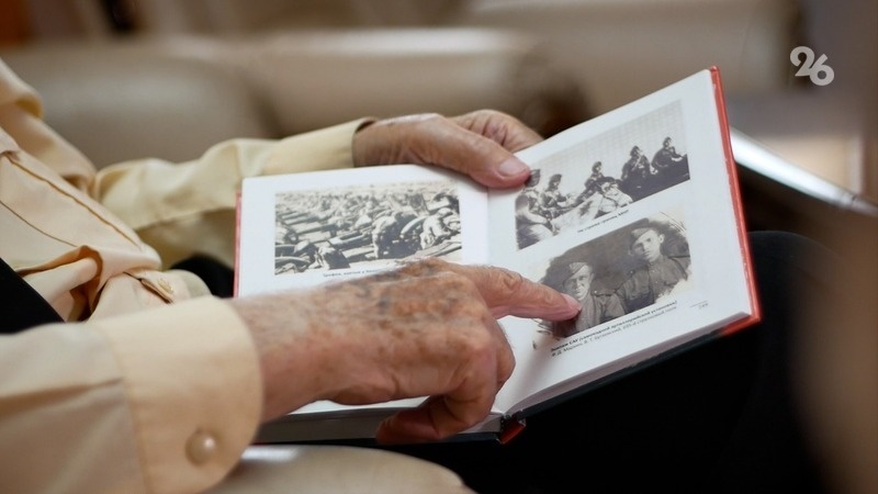    Ветеран Великой Отечественной войны показывает армейские фотографии Фото: Максим Семашко / / ИА «Победа26»