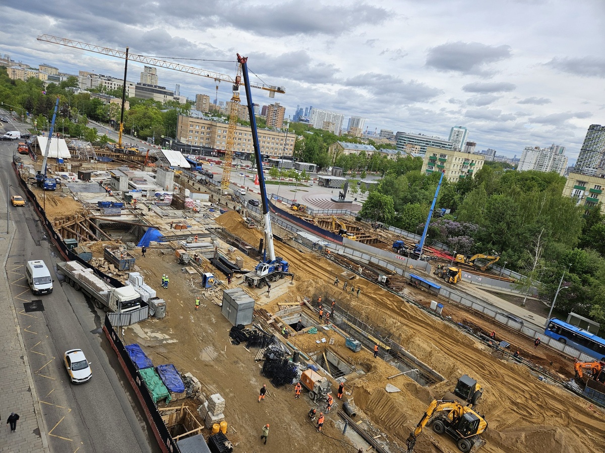 📷 1.1: В западном торце площадки начато крепление брезента на металлоконструкциях временного навеса над зоной проведения работ по строительству пересадки (для защиты от осадков на период демонтажа верхнего перекрытия станции Калужско-Рижской линии). Ведётся сооружение вентиляционных киосков, два из них практически полностью готовы в монолите.