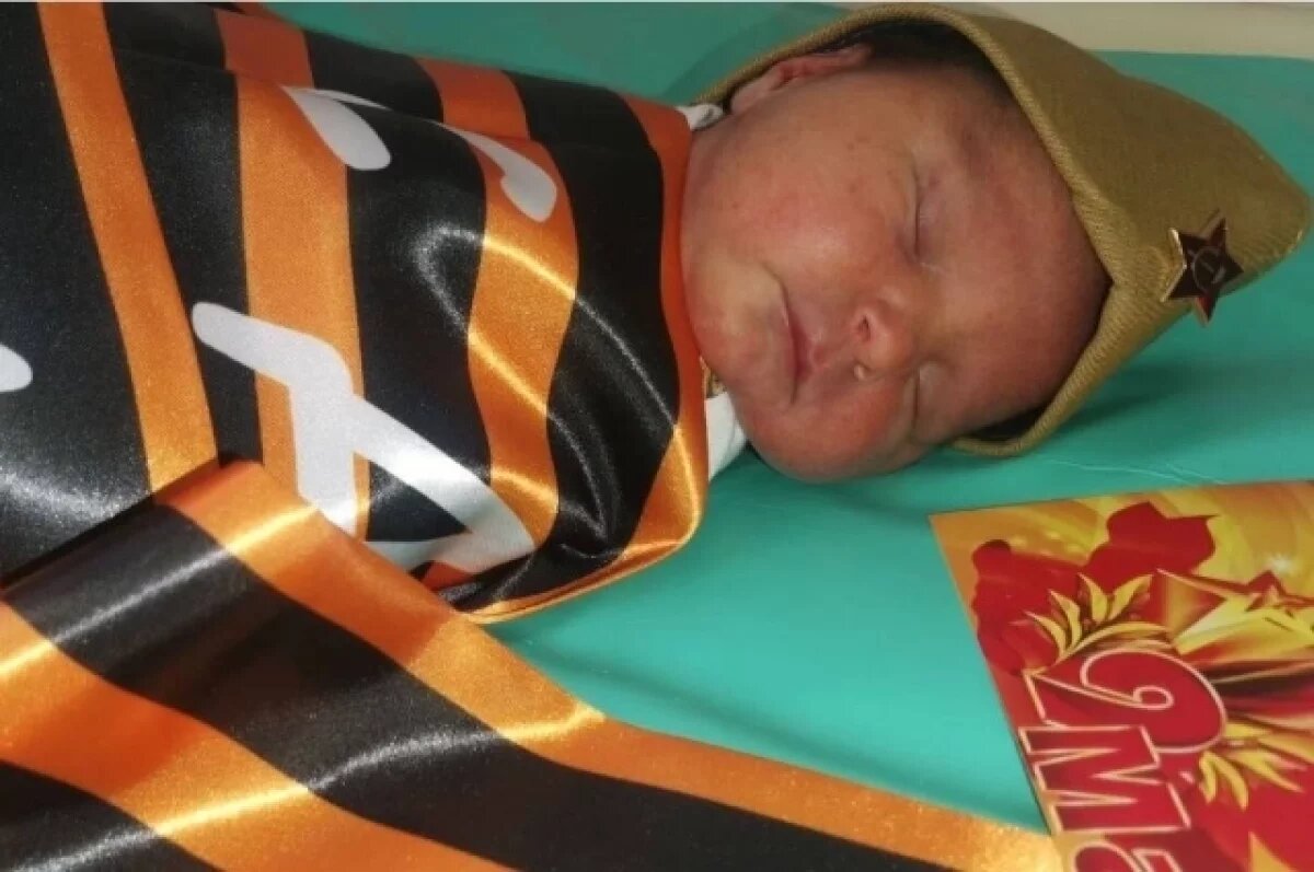    Малыша подготовили к поездке домой в символике Дня Победы.