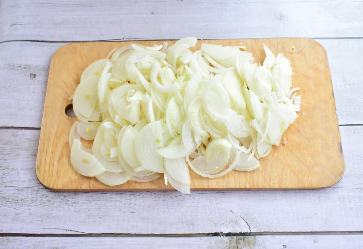 Лук очистите от шелухи и ополосните в холодной воде. Затем нарежьте полукольцами и помните его руками. От этого лук станет мягче и быстрее пустит сок, а значит лучше пропитает мясо.